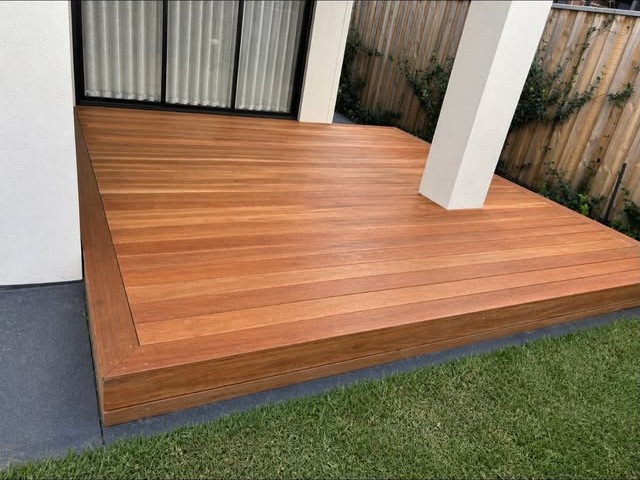 Hardwood deck with a single step down to the lawn